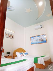a bedroom with two beds and a ceiling with stars at Noel Homestay in Hiếu Xương