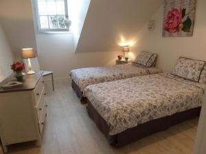 Un dormitorio con dos camas y una mesa y una ventana. en Gîte Moderne 10 Pers. en Touraine avec Jardin, WiFi, Près de la Vienne et Vignobles de Chinon - FR-1-381-395, en Cravant-les-Coteaux