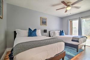 two beds in a room with a ceiling fan at Lovely Lauderhill Retreat Less Than 12 Mi to Beach! in Lauderhill