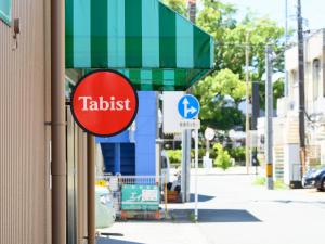 una señal en el lateral de un edificio al lado de una calle en Tabist IWATA Station Hotel en Iwata