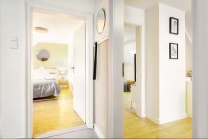 um quarto branco com uma cama e um corredor em Stay Awesome - Modernes Apartment am Botanischen Garten em Kassel
