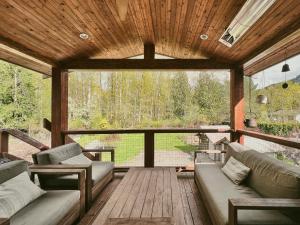 un porche cubierto con sofás y techo de madera en Unique Upper Suite Near Lakes, River, Hiking, Fishing, Bike Trails en Chilliwack