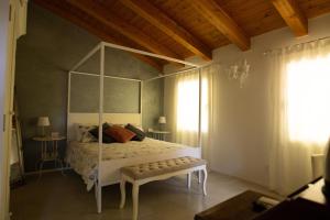 a bedroom with a white canopy bed with a bench at Ca' Ottantanove in Mestre