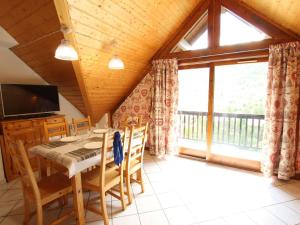 a dining room with a table and chairs and a large window at Appartement 3 pièces, proche Serre Chevalier, calme, 5 couchages, garage, sans ascenseur - FR-1-330F-151 in Serre Chevalier