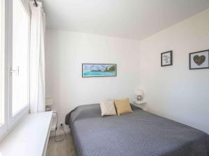 een kleine slaapkamer met een bed en een raam bij Appartement Saint-Jean-de-Luz, 2 pièces, 4 personnes - FR-1-4-524 in Saint-Jean-de-Luz