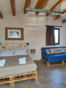 a bedroom with a bed and a blue couch at AgriBarocco in Noto