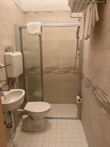 a bathroom with a shower and a toilet and a sink at Hotel Aron in Rimini
