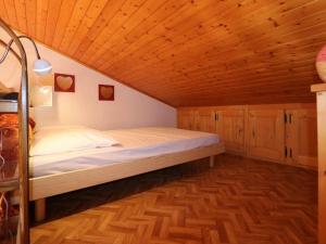 ラ・ロジエールにあるStudio Montvalezan-La Rosière, 1 pièce, 6 personnes - FR-1-398-550の木製の天井の客室のベッド1台分です。