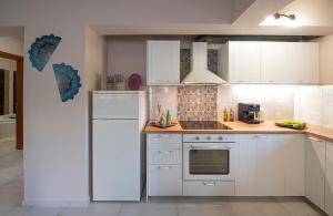 une cuisine avec des armoires blanches et un réfrigérateur blanc dans l'établissement Colored Dreams, à Bridgeport