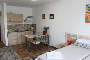 a room with a bed and a kitchen with a table and chairs at VILA ONIX in Săcueni