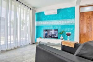a living room with a couch and a tv at Contemporary Private Studio with Pool and Kitchen in Beira