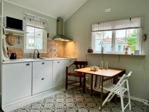 a kitchen with a wooden table and a table and chairs at Ekverandan in Höganäs
