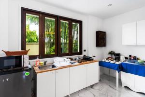 a kitchen with white cabinets and a sink and a window at Sclass 2 Luxe Pools Villa & Breakfast , city area in Chiang Mai