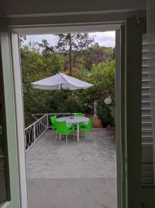 ヴェリ・ロシニュにあるHoliday Home Paradizoのパティオ(パラソル付きのテーブルと椅子付)