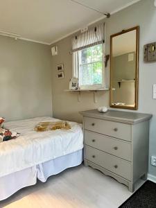 a bedroom with a bed and a dresser and a mirror at Ekverandan in Höganäs