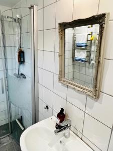 uma casa de banho com um lavatório e um espelho em Ekverandan em Höganäs