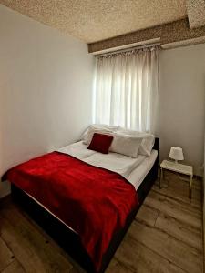 a bedroom with a large bed with a red blanket at Apartamenty Katarina in Ustrzyki Dolne