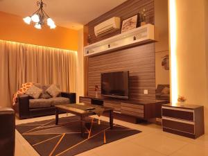 sala de estar con sofá y TV de pantalla plana en Ipoh Premier Suites @ Kinta Riverfront by DDV, en Ipoh