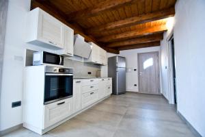 a kitchen with white cabinets and a refrigerator at Villa Infinity in Tergu