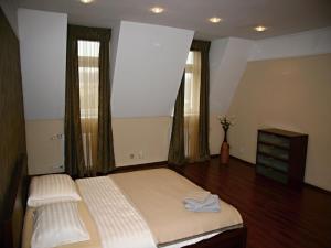 カルロヴィ・ヴァリにあるApartmán Dr. Englaのベッドルーム1室(ベッド1台、ドレッサー、窓2つ付)