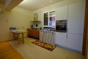 a kitchen with white appliances and a wooden floor at Sotto la luna Casa in campagna in Castel Bolognese