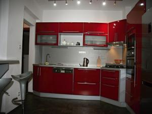 una cocina con armarios rojos y fregadero en Apartmán Dr. Engla, en Karlovy Vary