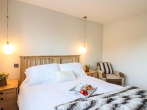 Un dormitorio con una cama con una bandeja de comida. en Cherry Blossom Place, en Tiptree