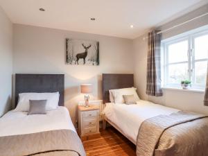 a bedroom with two beds and a deer picture on the wall at Cherry Blossom Place in Tiptree