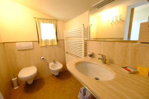 ein Badezimmer mit einem Waschbecken, einem WC und einem Spiegel in der Unterkunft Sotto la luna Casa in campagna in Castel Bolognese