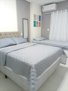 a bedroom with two twin beds and a window at Studio unita143 in Praia Grande
