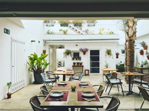 an outdoor patio with tables and chairs and a building at Chipibeach B&B, Hostal Boutique in Chipiona