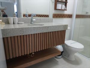 a bathroom with a sink and a toilet at Studio unita143 in Praia Grande +17 photos