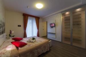 a bedroom with a bed with two red pillows at Hotel Venezia in Caorle