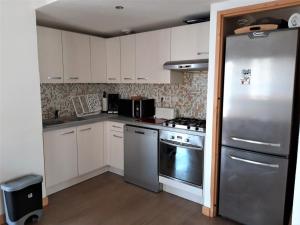 cocina con armarios blancos y nevera de acero inoxidable en Appartement Albiez-Montrond, 4 pièces, 8 personnes - FR-1-618-3, en Albiez-Montrond