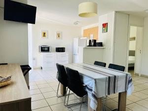 a kitchen and dining room with a table and chairs at Appartement T2 avec Piscine, Proche Thermes, Parking Souterrain et Terrasse - Cambo-les-Bains - FR-1-495-72 in Cambo-les-Bains
