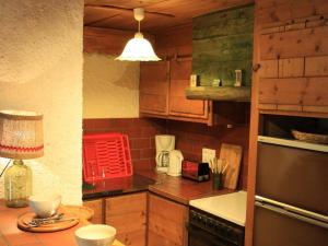 een keuken met houten kasten en een tafel met een lamp bij Appartement Albiez-le-Jeune, 2 pièces, 4 personnes - FR-1-618-12 