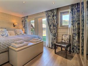 a bedroom with a bed and a chair and a window at Chalet Les Gets, 8 pièces, 14 personnes - FR-1-627-1 in Les Gets