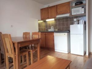 a kitchen with a table and a white refrigerator at Appartement Albiez-Montrond, 2 pièces, 4 personnes - FR-1-618-14 in Albiez-Montrond