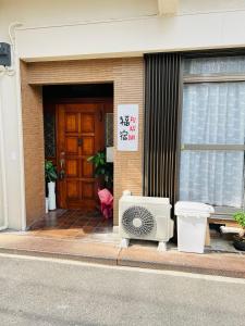 una puerta delantera de un edificio con un ventilador exterior en 福宿 Fukuinn 302号室, en Takamatsu