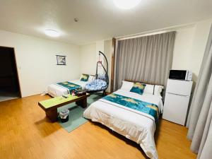 Habitación de hotel con 2 camas y mesa en 福宿 Fukuinn 302号室, en Takamatsu