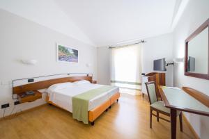 a hotel room with a bed and a desk and a table at Sardegna Termale Hotel&SPA in Sardara