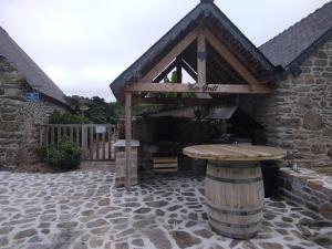 un edificio con un tavolo in legno di fronte ad esso di les gites du grenit a La Chapelle-Neuve