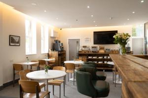 a restaurant with tables and chairs and a flat screen tv at Hotel DC, Stratford in London