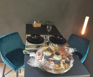 a table with a plate of food and two wine glasses at Paradis Secret in Beyne-Heusay