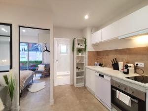 een keuken met witte kasten en een bed in een kamer bij Appartement T2 Cocooning, Secteur Doutre in Angers