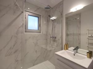 een badkamer met een douche, een wastafel en een spiegel bij Appartement T2 Cocooning, Secteur Doutre in Angers
