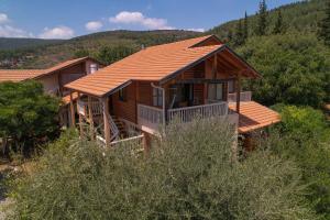 a log cabin in the woods with a roof at Aviv - Bakfar in Amirim in Amirim