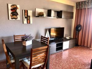 a dining room with a table and a television at Florazar de Ensueño in Cullera