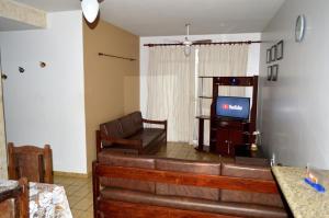 a living room with a couch and a television at Apartamento Di Cavalcanti in Guarapari