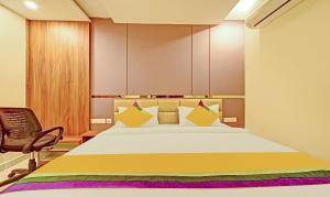 a bedroom with a bed and a chair at Itsy Hotels Sri Sai Grand Inn in Vijayawāda +22 photos